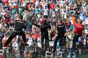 Helio Castroneves and his Team Penske crew climb the fence to celebrate their win in the second Dual In Detroit Sunday afternoon.  Photo by Chris Jones